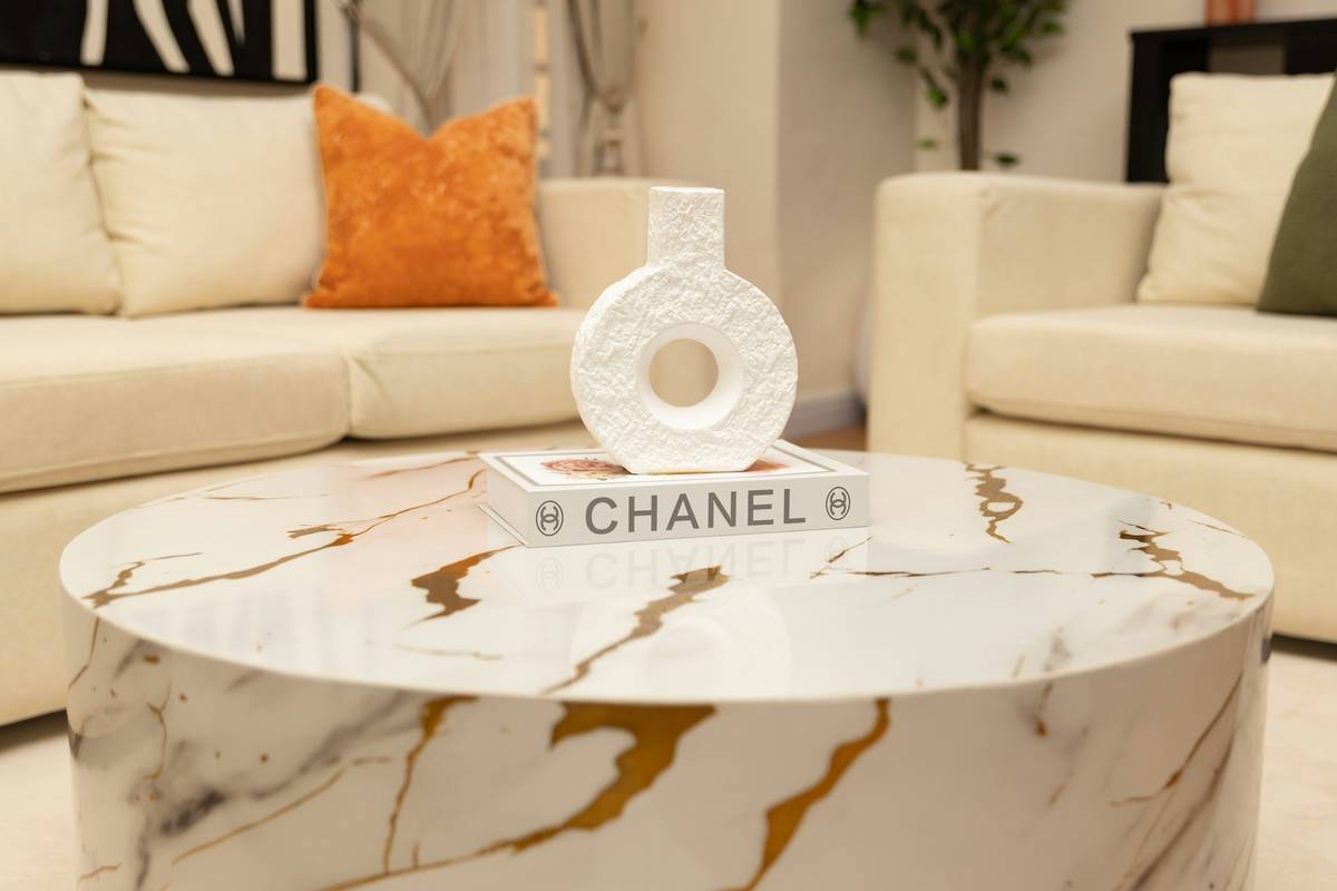 decorative ideas for coffee table showcasing a curated trio of textured boxes, a small potted plant, and a folded linen napkin on a light oak surface